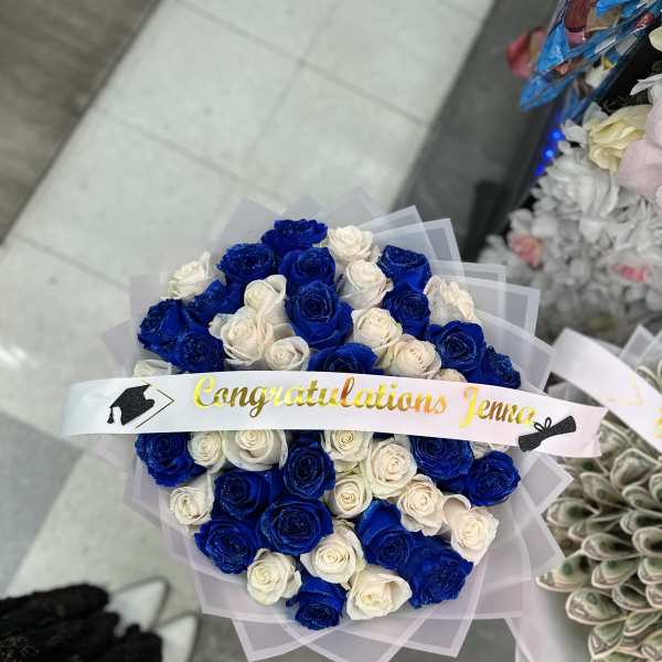 Bouquet of blue and white roses with a graduation ribbon