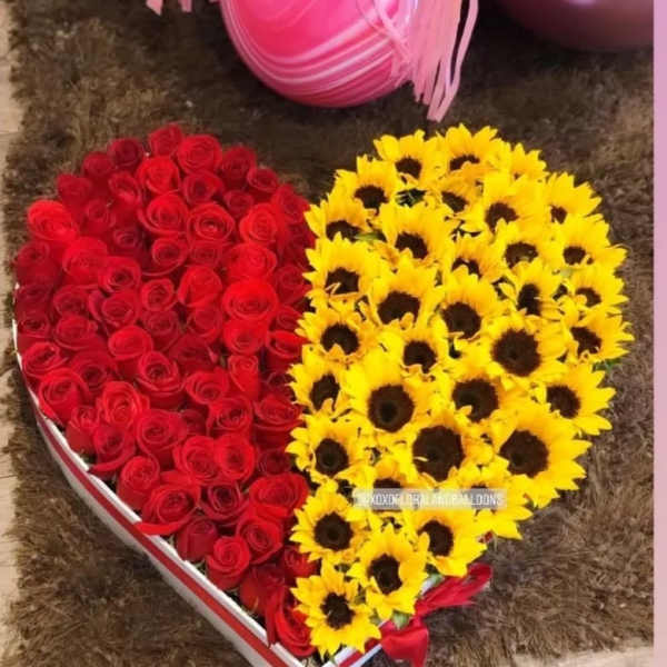 Heart-shaped box filled with red roses and yellow sunflowers