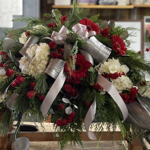 Large red and white floral arrangement with silver ribbon accents