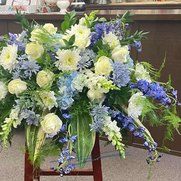 Large blue, white, and cream floral arrangement with cascading blooms
