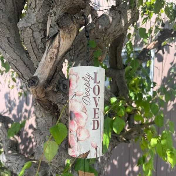 Decorative memorial sign hanging from a tree branch