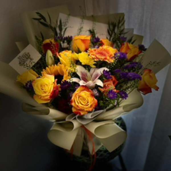 Bouquet of yellow and orange roses with sunflowers and purple accents