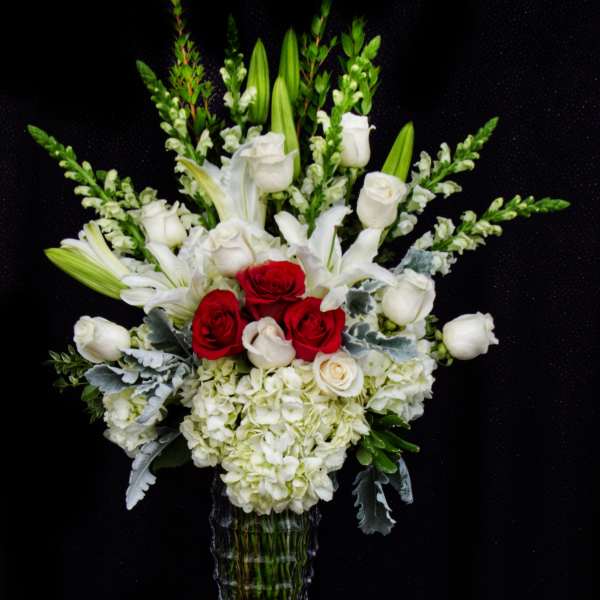 White and red floral arrangement in a clear glass vase