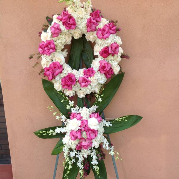 Standing floral wreath of pink and white roses on an easel