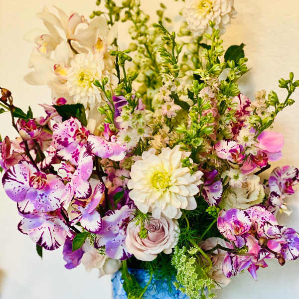Mixed pink, white, and purple flowers in a white vase
