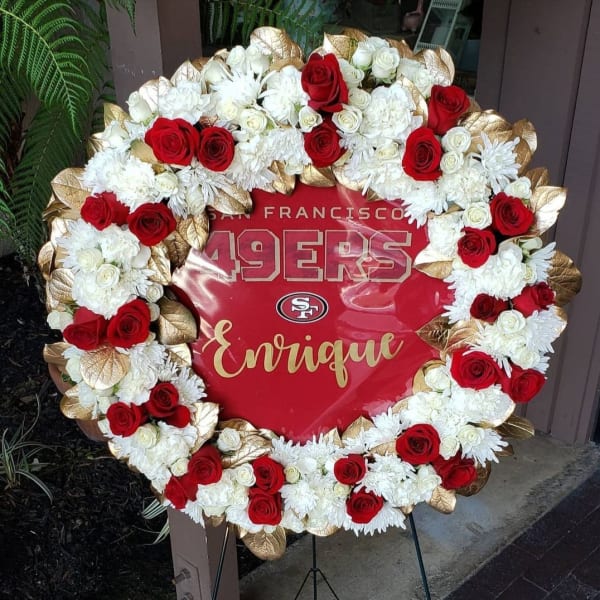 Heart-shaped floral wreath with red and white roses around a San Francisco 49ers sign