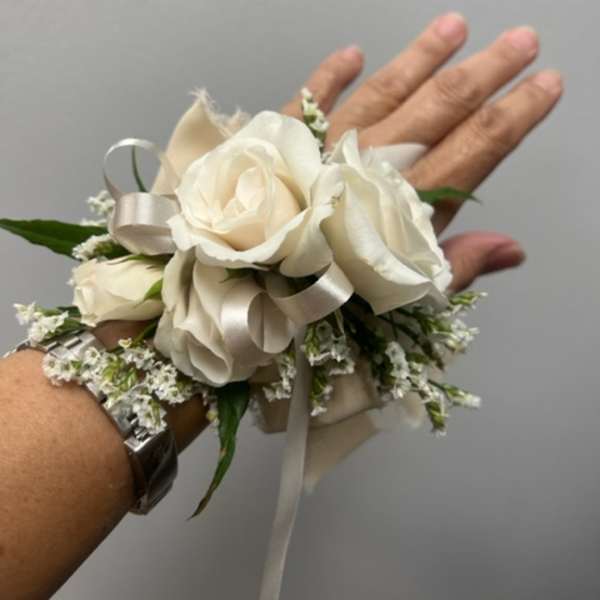 White rose wrist corsage with ribbon and small filler flowers