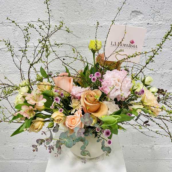 Pastel bouquet with roses, carnations, and alstroemeria in a white vase