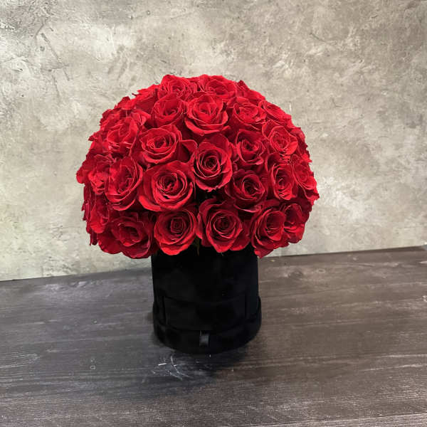 Round bouquet of red roses in a black box