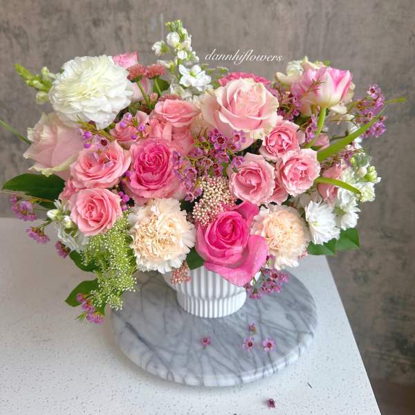 Pink and white rose bouquet in a white vase