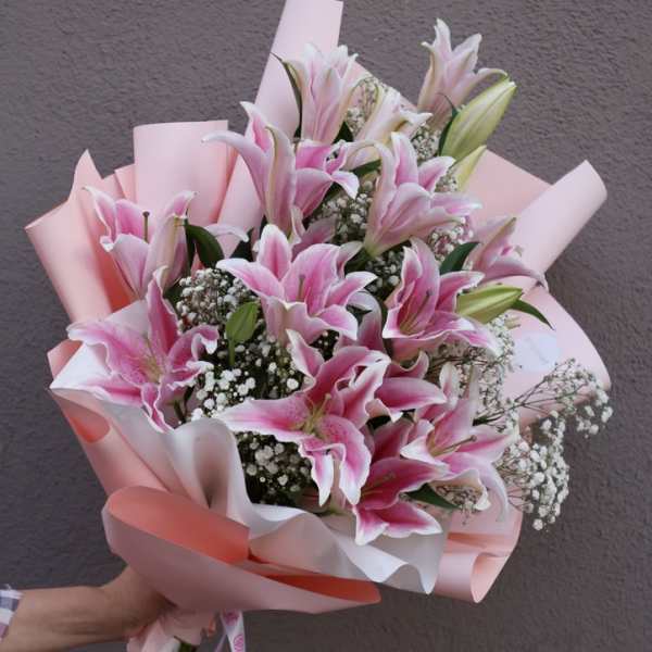 Pink lily bouquet wrapped in pastel paper