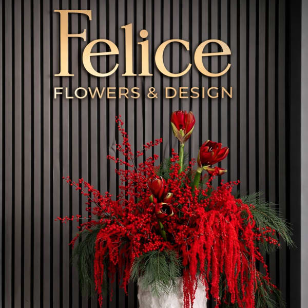 Red floral arrangement in a white textured vase