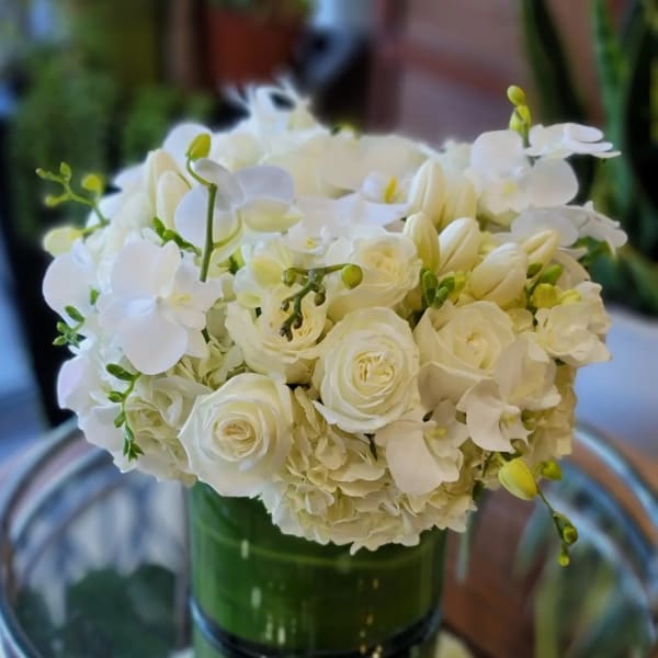 White floral bouquet in a green glass vase