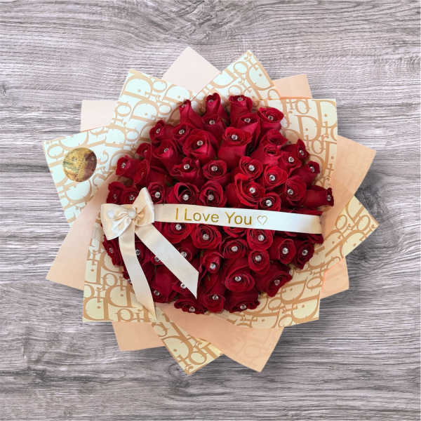 Bouquet of red roses wrapped in patterned paper with a ribbon