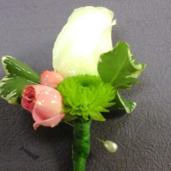 Boutonniere with a white rose, pink rosebud, and green accent flower