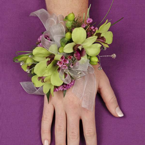 Hand corsage with green orchids, pink accents, and silver ribbon