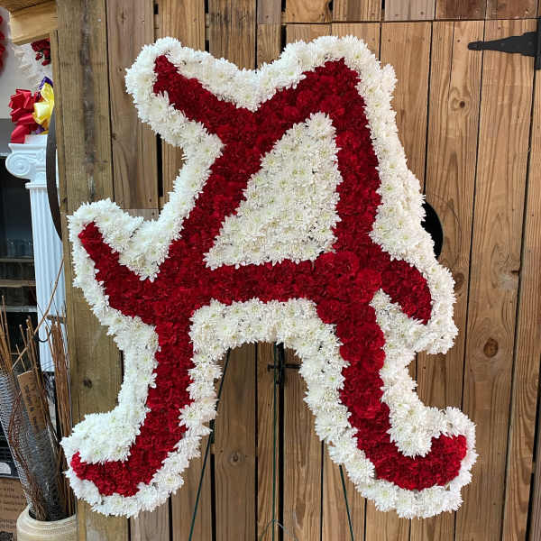 Red and white floral arrangement shaped like a cowboy boot on a stand