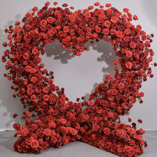 Heart-shaped floral display of red roses and small red blooms