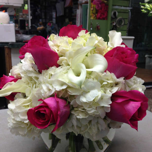 Pink roses and white calla lilies in a glass vase