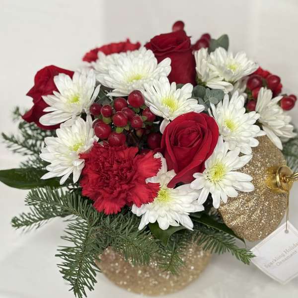 Red roses and white daisies in a glittery gold ornament container
