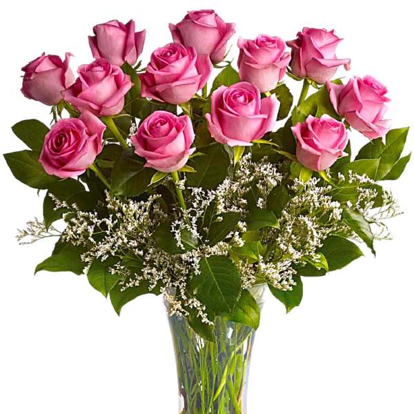 Pink roses arranged in a clear glass vase with white filler flowers