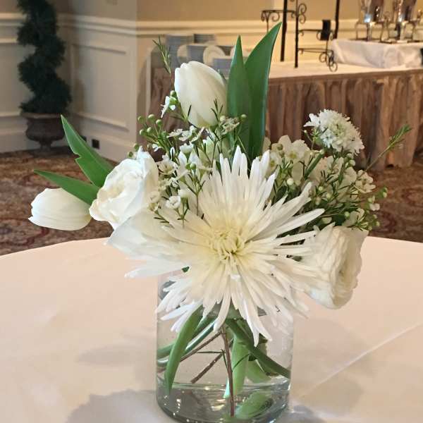 White floral arrangement in a clear glass vase on a table