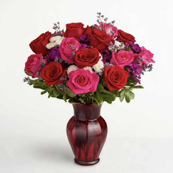 Bouquet of red and pink roses in a red glass vase