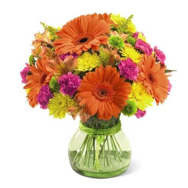 Orange and pink mixed bouquet in a green glass vase