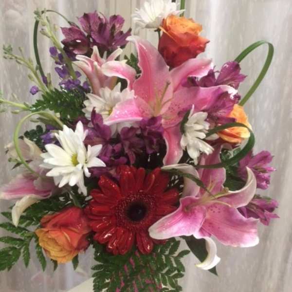 Mixed bouquet with pink lilies, red gerbera daisies, and orange roses