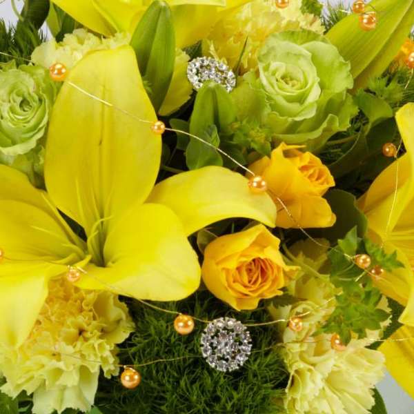 Yellow lilies and roses with green blooms and gold bead accents