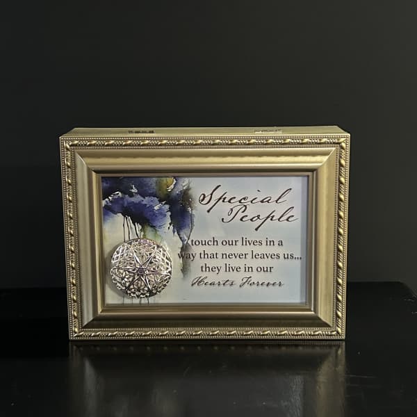 Framed memorial plaque with a decorative medallion and condolence message