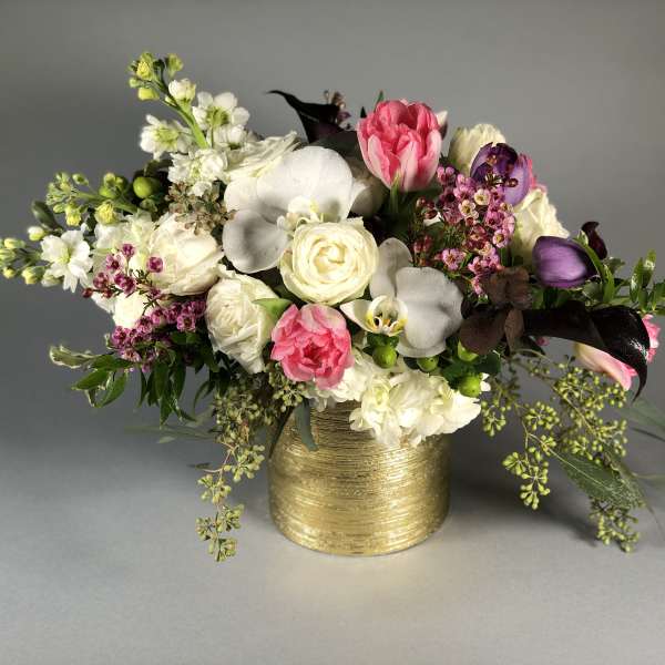 Bouquet of pink and white flowers in a gold vase