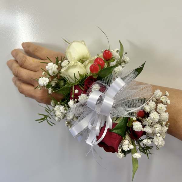 Wrist corsage with red and white roses and baby's breath