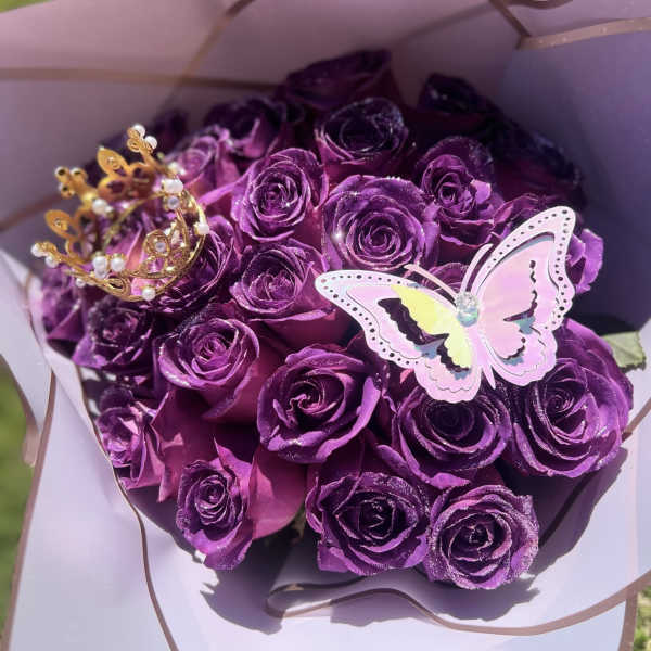Bouquet of purple roses with a butterfly and crown topper