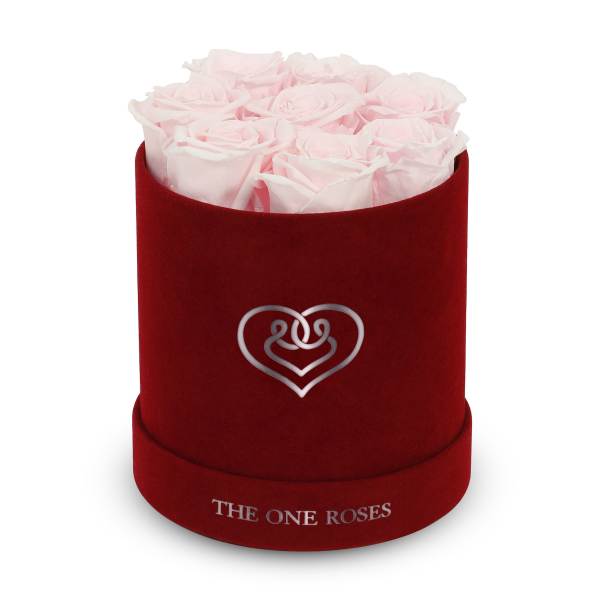 Pink roses in a red velvet hat box with a heart emblem
