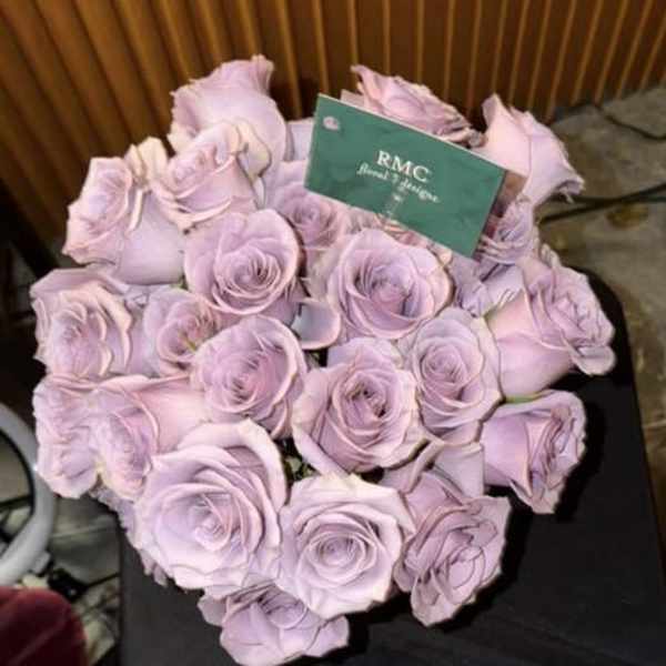 Bouquet of pale lavender roses with a card tucked in front