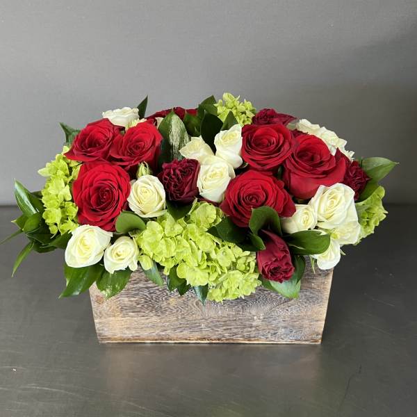 Red and white roses with green hydrangeas in a wooden box