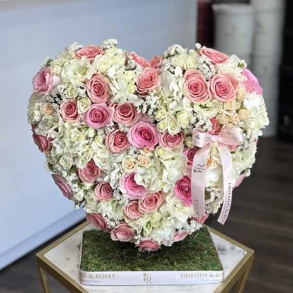 Heart-shaped bouquet of pink and white roses with hydrangeas