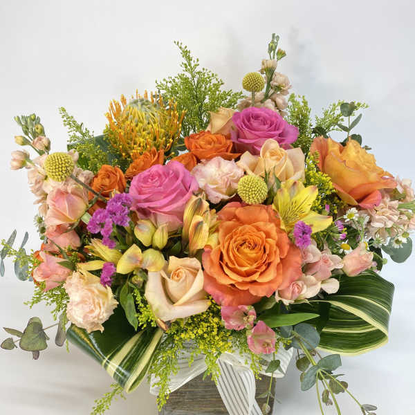 Mixed bouquet of orange and pink roses in a wooden box