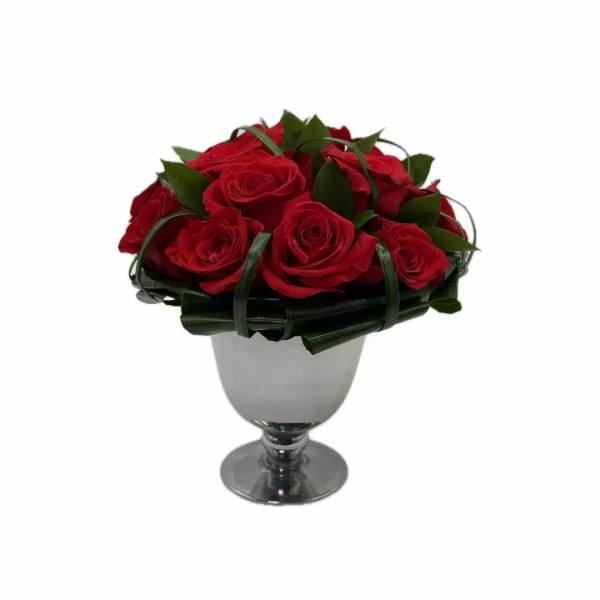 Red roses arranged in a silver goblet vase