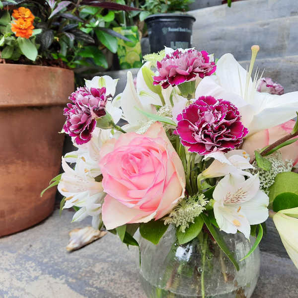 Pink rose and white lily bouquet in a glass vase