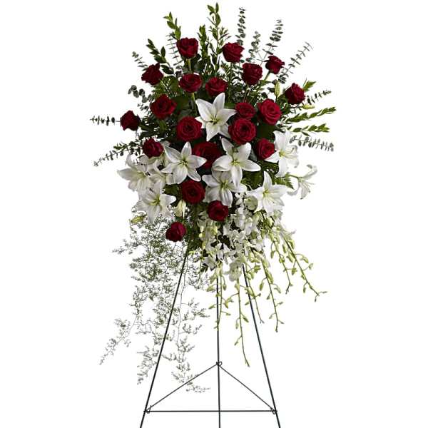 Standing floral spray with red roses and white lilies on an easel