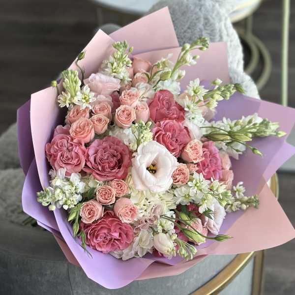 Pink and white bouquet of roses and lisianthus wrapped in pastel paper