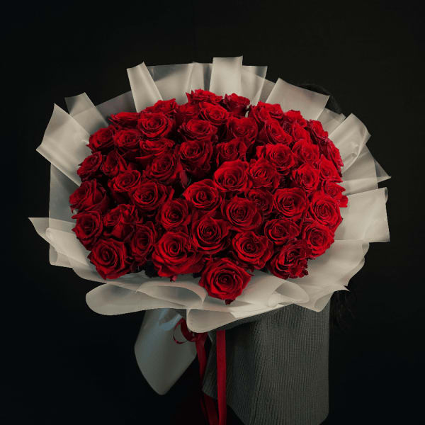 Large bouquet of red roses wrapped in white paper