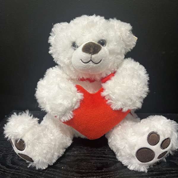 White teddy bear holding a red heart