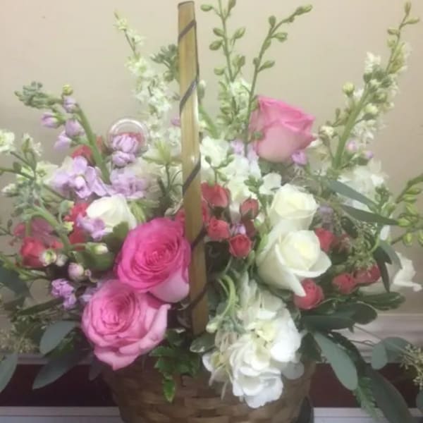 Basket arrangement of pink and white roses with lavender flowers