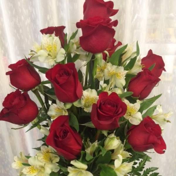 Bouquet of red roses and white alstroemeria in a clear vase