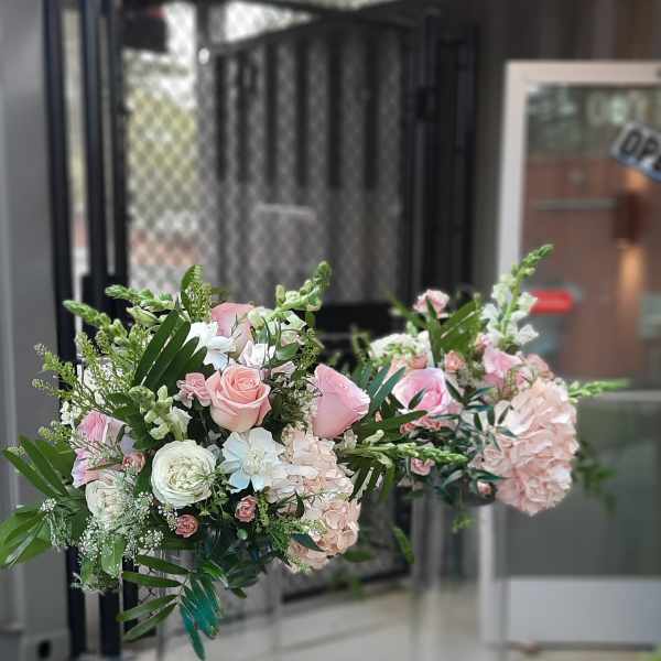 Pink and white floral arrangements in tall clear glass vases