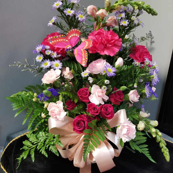 Pink and purple mixed flower arrangement with a satin bow