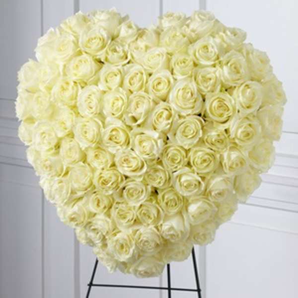 Large heart-shaped bouquet of cream roses on a stand